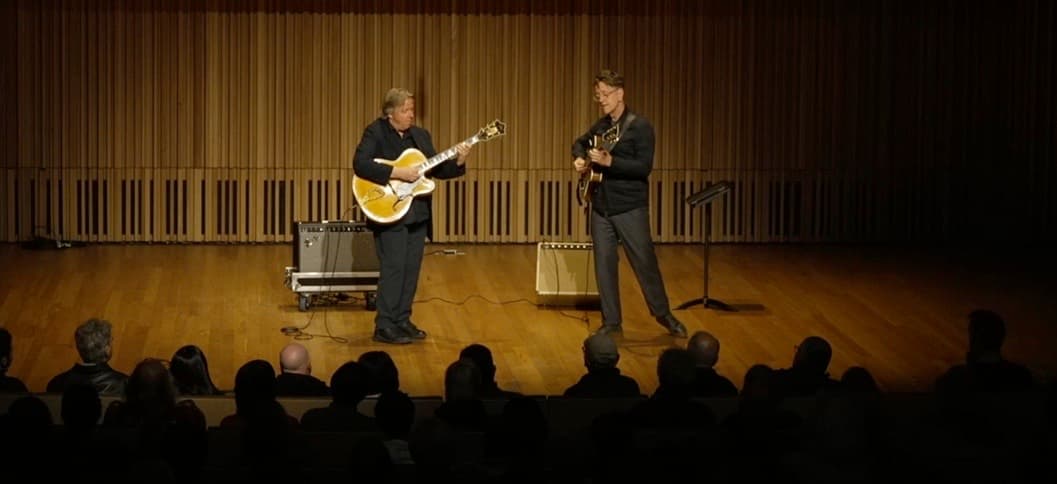Students learning guitar in a workshop